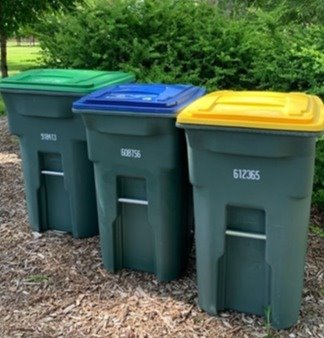 Three recycling bins outside. 