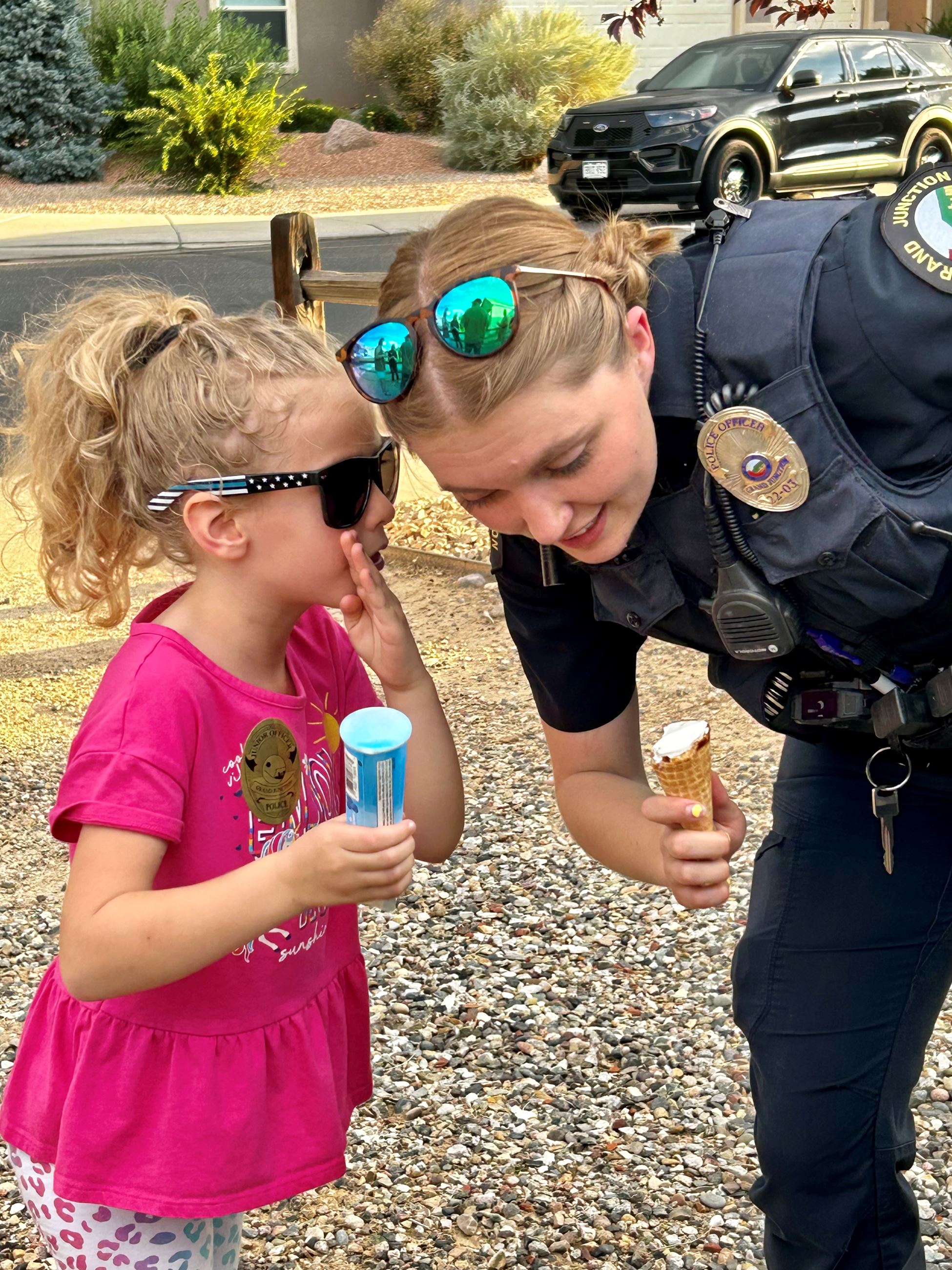 girl whispering to officer