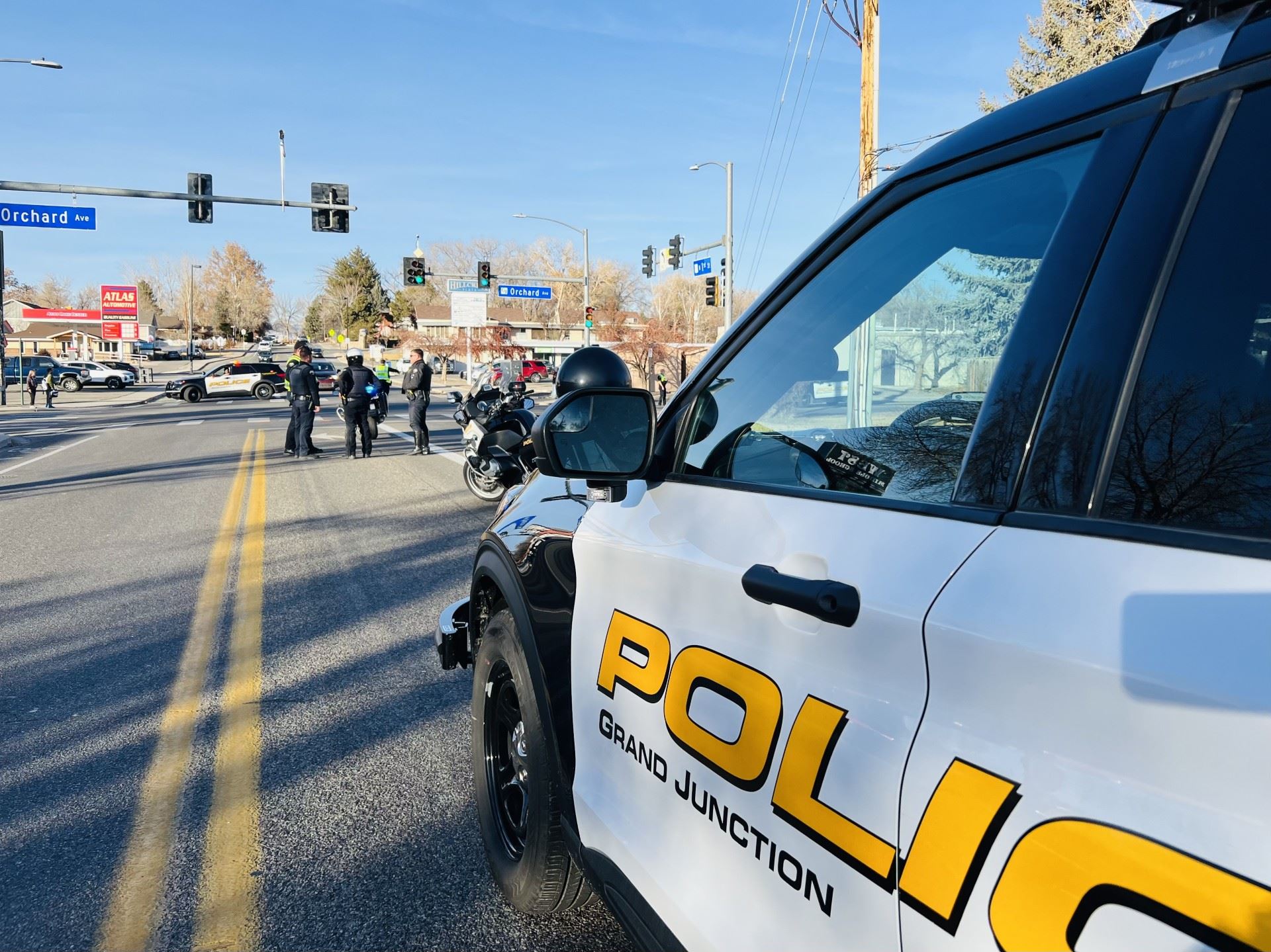 a police motorcycle and four police officers at a crash scene