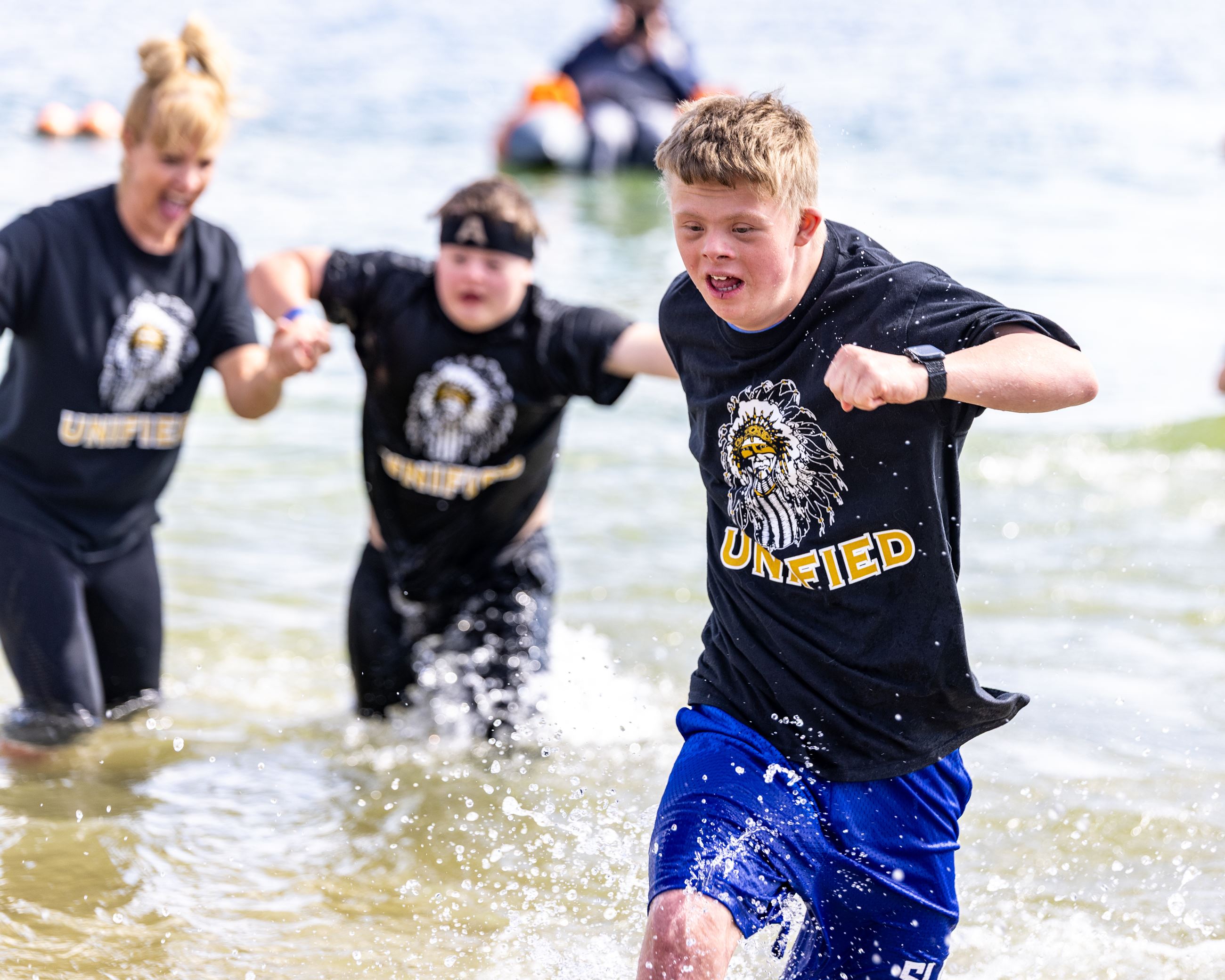 Three teens running out of a cold lake